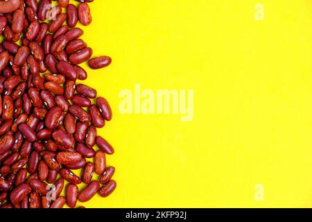 Grani fagioli grezzi sfondo giallo Foto Stock