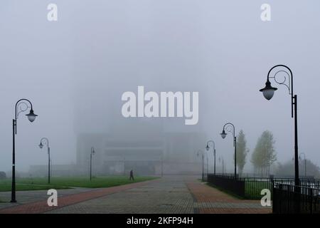 Parco pubblico e silhouette alto edificio in nebbia Foto Stock