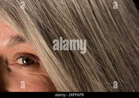 Primo piano di una donna anziana con capelli grigi. Foto Stock