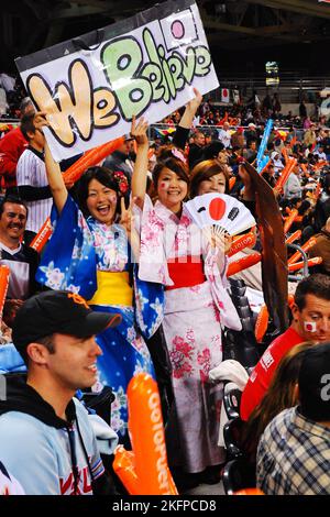 Giovani tifosi, vestite con tradizionali kimono giapponesi e con una bandiera, allietano la nazionale giapponese al World Baseball Classic Foto Stock