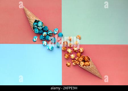 Cono gelato waffle con sfondo colorato Popcorn spill-terracota. fast food snack cornucopia Foto Stock