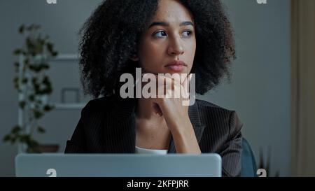 Premuroso giovane donna d'affari afroamericana ragazza freelance lavoratore guardando lo schermo del laptop lavoro sul computer in ufficio pensare nuovo business Foto Stock