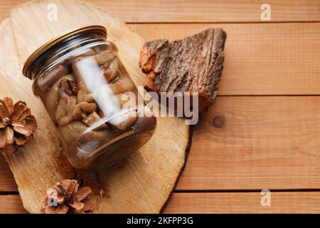 Funghi sottaceto su tavola rustica in legno. Conserve fatte in casa in un vaso di vetro. Spazio di copia Foto Stock