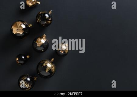 Natale nero baubles decorativo dorato foglia di potal placcato con bokeh su sfondo nero. Banner natalizio con spazio per la copia. Biglietto di Natale di lusso moderno. Foto Stock