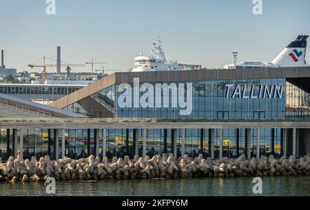 Estonia, Tallinn - 21 luglio 2022: I traghetti salgono sopra il terminal delle navi da crociera in vetro e legno sotto il cielo blu chiaro del mattino. Fermi ondulati davanti e. Foto Stock