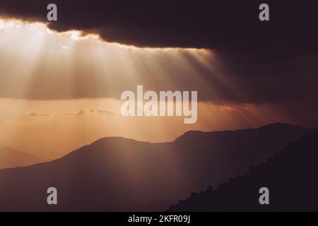 Travi a vista sulle colline himalayane dalle linee silhouette, a sud della catena montuosa dell'Annapurna. Nepal. Foto Stock