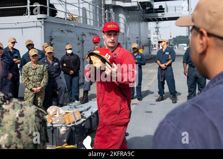 YOKOSUKA, Giappone (3 ottobre 2022) – Damage Controlman 1st Class Brandon Carrick, da Cathedral City, Calif., istruisce i marinai USS Blue Ridge (LCC 19) sui componenti di un casco antincendio navale durante la formazione di valutazione MOB-D (Mobility Damage Control Warfare) a bordo della nave ammiraglia US 7th Fleet, 3 ottobre 2022. Le valutazioni MOB-D sono una serie di esercitazioni volte a valutare la capacità di una nave di rispondere alle emergenze e mantenere la nave a galla in situazioni di emergenza. Blue Ridge è la più antica nave operativa della Marina e, come 7th Fleet Command ship, lavora attivamente per promuovere le relazioni Foto Stock