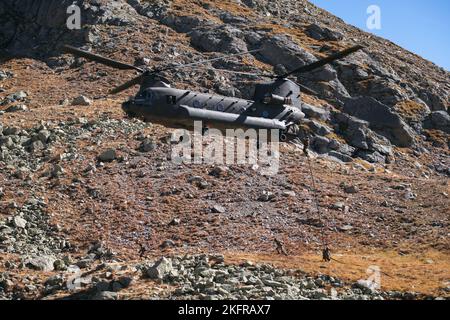 I soldati dell'esercito italiano con la Brigata Alpini si opporono a un elicottero CH-47 Chinook per attaccare un obiettivo durante un esercizio di fuoco in bianco accanto ai paracadutisti dell'esercito statunitense assegnati a 2nd battaglione, 503rd reggimento di fanteria paracadute come parte dell'esercizio Summer Resolve nella Provincia di Bolzano, Italia, 3 ottobre 2022. Exercise Alpine Star è un esercizio annuale di addestramento in montagna e artico organizzato dall'Esercito Italiano, multinazionale e multifase. I paracadutisti della ricognizione della Brigata aerea 173rd si integrano con alcune aziende selezionate della Brigata Alpini dell’Esercito Italiano per imparare la tecnica Foto Stock