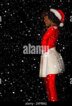 Una donna afro-americana vestita con un abito di Natale è raffigurata in nero con una copertura di neve, 18 novembre 2022, a Mobile, Alabama. Foto Stock
