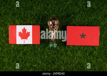 20 novembre 2022, Doha, Qatar. Bandiere del Marocco e del Canada e il trofeo della Coppa del mondo FIFA sul prato verde dello stadio. Foto Stock