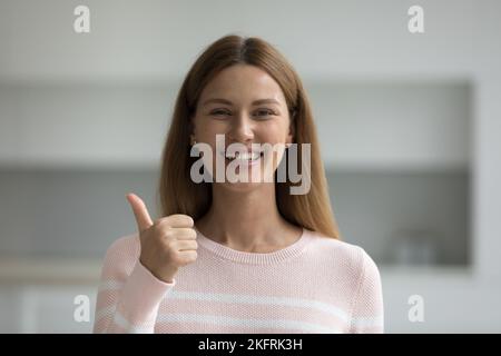 Ritratto di donna che mostra pollici verso l'alto guardare la fotocamera Foto Stock