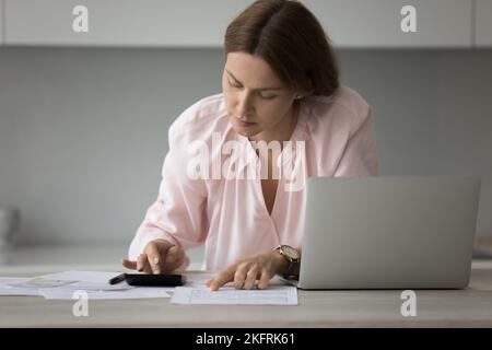 Donna focalizzata gestisce le finanze personali a casa Foto Stock