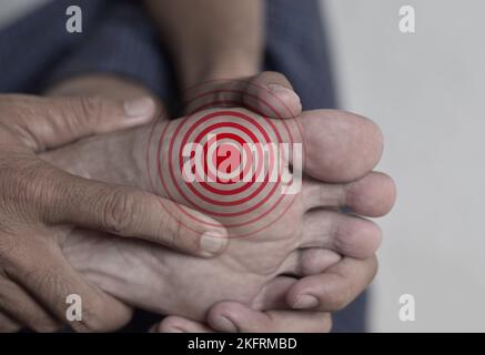 Formicolio e sensazione di bruciore ai piedi dell'uomo asiatico con diabete. Dolore ai piedi. Problemi di neuropatia sensoriale. Fascite plantare. Pelle pruriginosa. Foto Stock