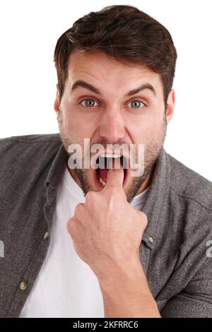 Mi fai male. Primo piano studio ritratto di un giovane uomo mettere il dito in bocca per suggerire lancio. Foto Stock