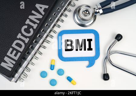 Medicina e concetto di salute. Sulla tavola è riportato uno stetoscopio, un diario e un segno con l'iscrizione BMI Foto Stock