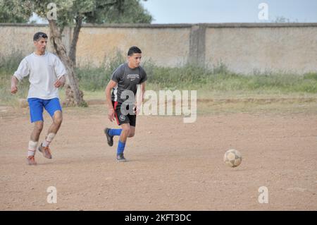 Uomini che giocano a calcio, insediamento della popolazione più povera al di fuori di Fes, Marocco, Africa Foto Stock