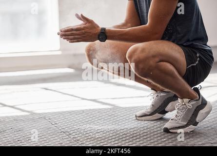 Uomo, polvere e mani in palestra per il fitness, il benessere o il sollevamento pesi mentre si squat su pavimenti in gomma. Bodybuilder sano, gesso o pronto per l'esercizio Foto Stock