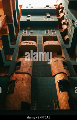 Dall'esterno inferiore di un edificio distintivo con balconi con pareti in mattoni e finestre con pareti verdi situate in Spagna Foto Stock