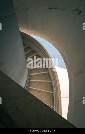 Dall'alto di una scala a chiocciola in cemento in un edificio urbano situato nelle Asturie nelle giornate di sole Foto Stock