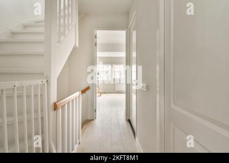 Interno di una casa con scale ad un piano superiore in un ambiente luminoso Foto Stock