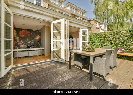 Cortile di una casa accanto ad altre case allineate con tavolo e sedie Foto Stock