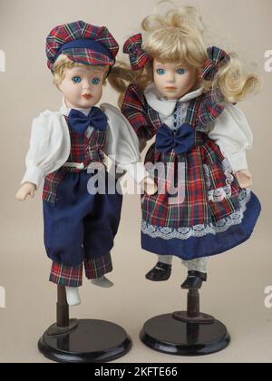 Bambole in porcellana vintage due ragazze con capelli biondi in tute a scacchi. Le bambole di porcellana erano popolari nel 18th ° secolo in Francia. Sono stati usati per il fotoricettore Foto Stock