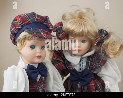 Bambole in porcellana vintage due ragazze con capelli biondi in tute a scacchi. Le bambole di porcellana erano popolari nel 18th ° secolo in Francia. Sono stati usati per il fotoricettore Foto Stock