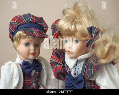 Bambole in porcellana vintage due ragazze con capelli biondi in tute a scacchi. Le bambole di porcellana erano popolari nel 18th ° secolo in Francia. Sono stati usati per il fotoricettore Foto Stock