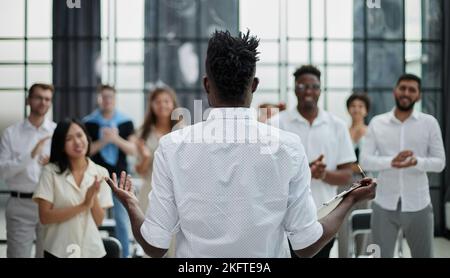 Vista posteriore dei colleghi aziendali che discutono di un rapporto in un ufficio moderno. Foto Stock