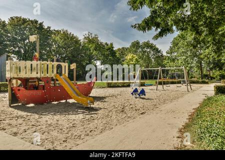 Piccolo e semplice patio con piccolo giardino vicino al parco giochi Foto Stock