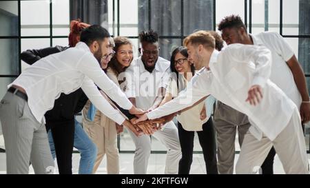 Angolo di Alta Vista multirazziale amico di impilaggio assieme a mano Foto Stock