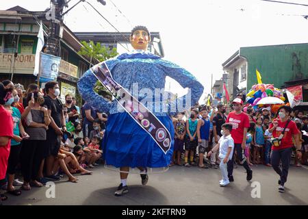 Angono, Rizal, Filippine. 20th Nov 2022. La sfilata dei burattini giganti nella capitale dell'arte delle Filippine è tornata dopo due anni di pandemia. Il Festival Higantes (gigante) sfilano le strade di Angono, provincia di Rizal. Le marionette della testa della macchina di carta sono state originariamente fatte per mettere a vergogna funzionari corrotti durante il governo spagnolo. Ora, gli Higantes sono venuti un lungo cammino e si evolvono in un festival sui tempi moderni dall'era spagnola. Il festival porta gioia e divertimento alla gente del paese di Angono e ai turisti. Ora, portano un sash per rappresentare qualcuno o promuovere qualcosa con Foto Stock