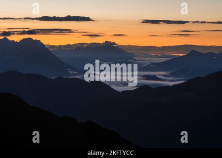 Vista dal Monte Veitsberg sull'alba sulle montagne Kaiser e sulle Alpi di Kitzbühel, Tirolo, Austria Foto Stock