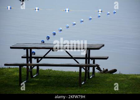 Tavolo da picnic umido e shiy con acqua e boutys sul retro Foto Stock