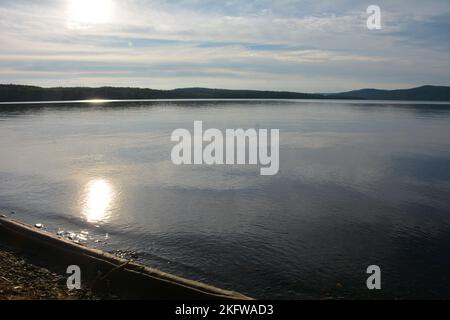 Tavolo da picnic umido e shiy con acqua e boutys sul retro Foto Stock