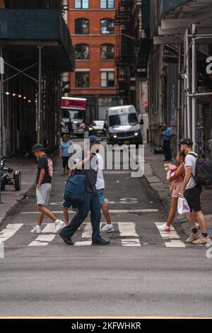 Una verticale di persone che camminano all'incrocio della strada di Chinatown a Manhattan, New York Foto Stock