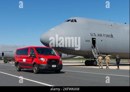 Cappellano (Capt.) William Guy, a sinistra, 436th Airlift Wing cappellano; Tech. SGT. Eric Feliciano, centro, 512th aviatore di affari religiosi di AW; e cari Matthews, destra, organizzazioni di servizio Unito Delaware supervisore di operazioni del centro senior, camminare fino a un C-5M Super Galaxy durante una visita Friends on the Flight Line a dover Air Force base, Delaware, 11 ottobre 2022. Il Holy Roller van ha fatto numerose fermate sulla linea di volo e presso il 436th Maintenance Squadron Isochronal Dock che offre bevande, panini e snack che sono stati forniti dall'USO. Foto Stock