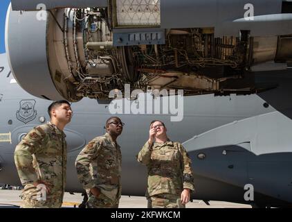 Staff Sgt. Robert Johnson, destra, 736th manutenzione aeromobili Squadron C-17 Globemaster III capo equipaggio, brief Chaplain (Capt.) William Guy, centro, 436th Airlift Wing cappellano e tecnico. SGT. Eric Feliciano, ha lasciato 512th aviatore per gli affari religiosi AW nelle aree di ispezione del motore durante un'ispezione di controllo della stazione di casa di 180 giorni eseguita presso la base dell'aeronautica militare di dover, Delaware, 11 ottobre 2022. Durante la visita Friends on the Flight Line, il pulmino Holy Roller ha consegnato bevande, panini e spuntini forniti dalle organizzazioni United Service, ai manutentori di aeromobili in vari squadroni sotto gli anni '436th Foto Stock