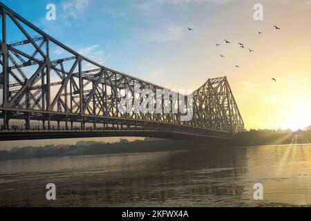 Ponte Howrah all'alba. Un famoso ponte a sbalzo costruito sul fiume Ganges che collega la città di Kolkata al quartiere di Howrah. Foto Stock