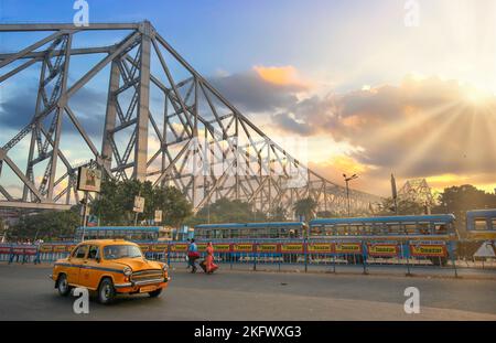 Taxi parcheggiato sulla strada cittadina con vista sullo storico ponte Howrah Kolkata, India all'alba. Foto Stock