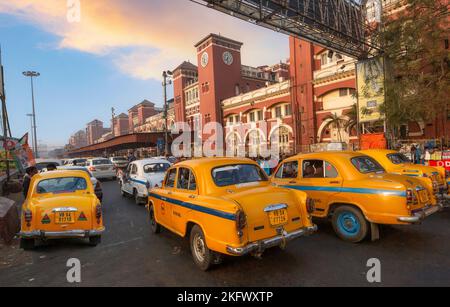 Taxi giallo in coda alla stazione ferroviaria di Howrah in attesa di passeggeri e pendolari a Kolkata, India Foto Stock