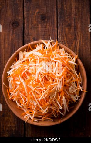 Insalata invernale di carote e sedano in una ciotola su fondo di legno Foto Stock