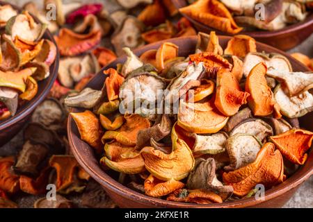 Natura morta rurale, sfondo - frutta secca da mele e pere in primo piano recipiente di argilla, fuoco selettivo Foto Stock