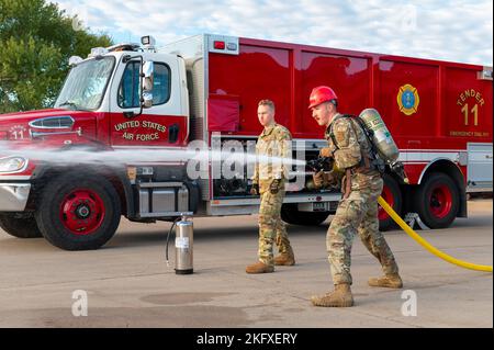 Senior Airman Trent Schroedl, 22nd ingegnere civile Squadron Structural journeyman, spruzza un tubo da fuoco ad un obiettivo nel concorso Fire Muster 13 ottobre 2022, alla base dell'aeronautica militare McConnell, Kansas. Quattro squadre di quattro membri hanno gareggiato per completare sette eventi il più rapidamente possibile, i sette eventi hanno mostrato le sfide che i vigili del fuoco vedono mentre svolgono i loro compiti. Foto Stock