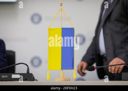 Profondità di campo bassa (focus selettivo) dettagli con una bandiera Ucraina durante una conferenza stampa. Foto Stock