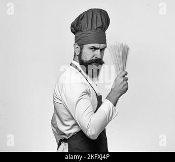 Cuocete con il volto stretto in uniforme bordeaux per tenere la pasta secca Foto Stock