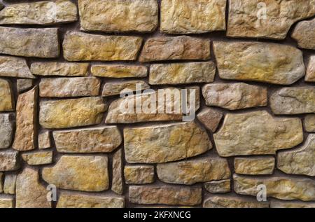 La struttura di un muro di pietra fiancheggiato da ciottoli. Trama Foto Stock