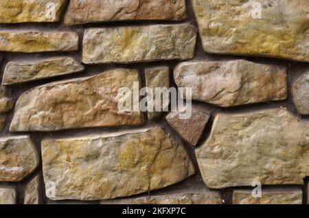 La struttura di un muro di pietra fiancheggiato da ciottoli. Trama Foto Stock