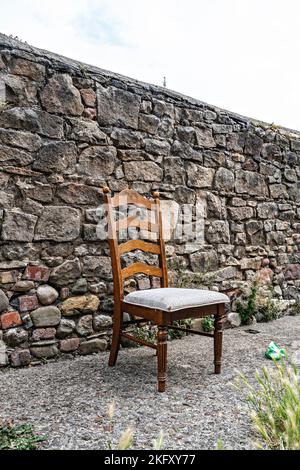 Sedia da pranzo in legno lasciata in strada Foto Stock