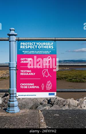 Proteggiti, rispetta gli altri - poster di Covid esposti lungo Morecambe Promenade, Lancashire Foto Stock